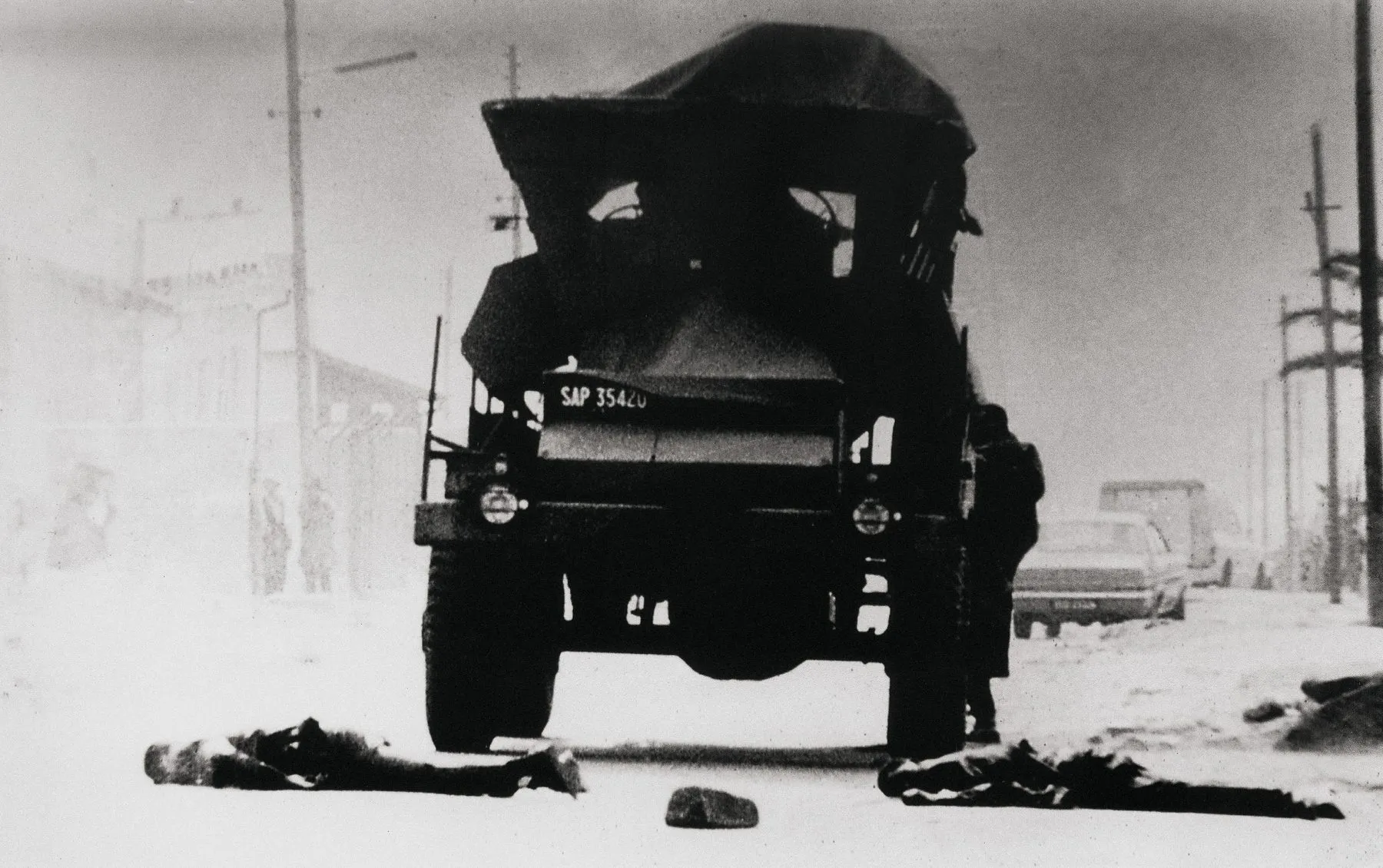 Dead lie before an army vehicle near Mzimhlope, days after June 16. Photographed by Alf Kumalo from the rear window of a car.