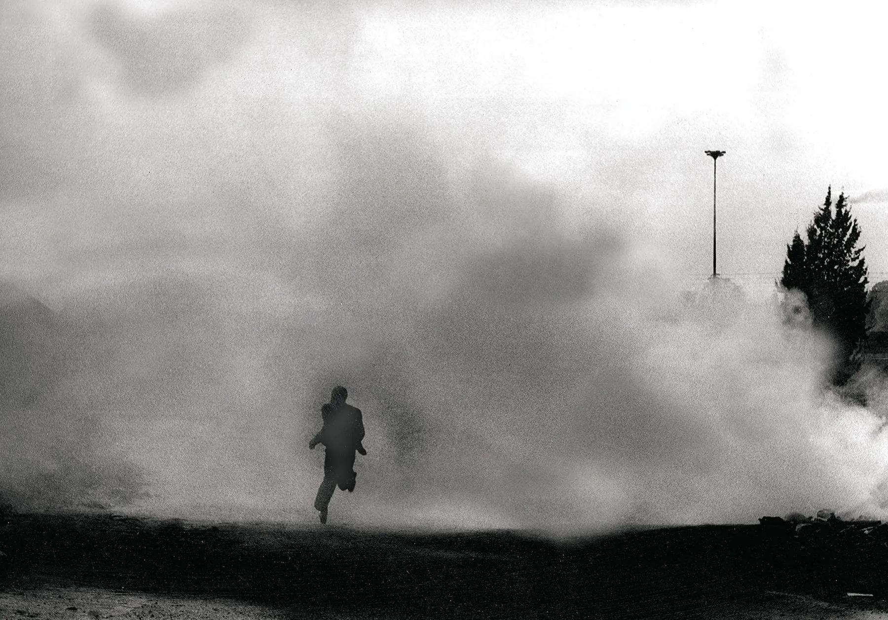 A Soweto resident runs from the toxic smell of teargas, 1976.